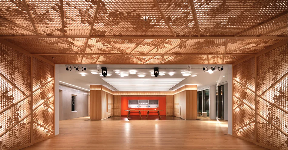 Geometric wooden kumiko panels span the walls and ceiling of a contemporary conference space