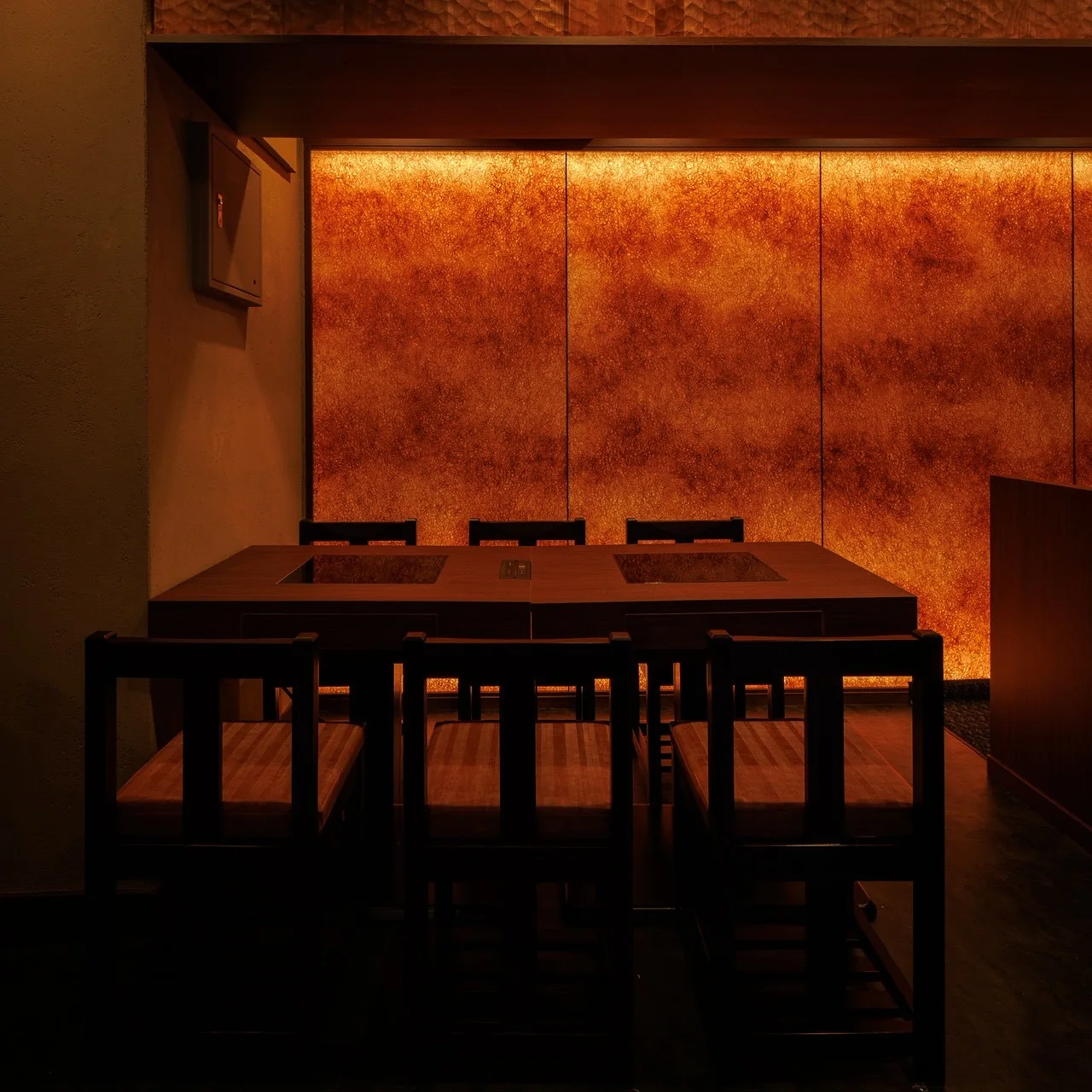 Textured copper-coloured washi wall behind a timber restaurant table